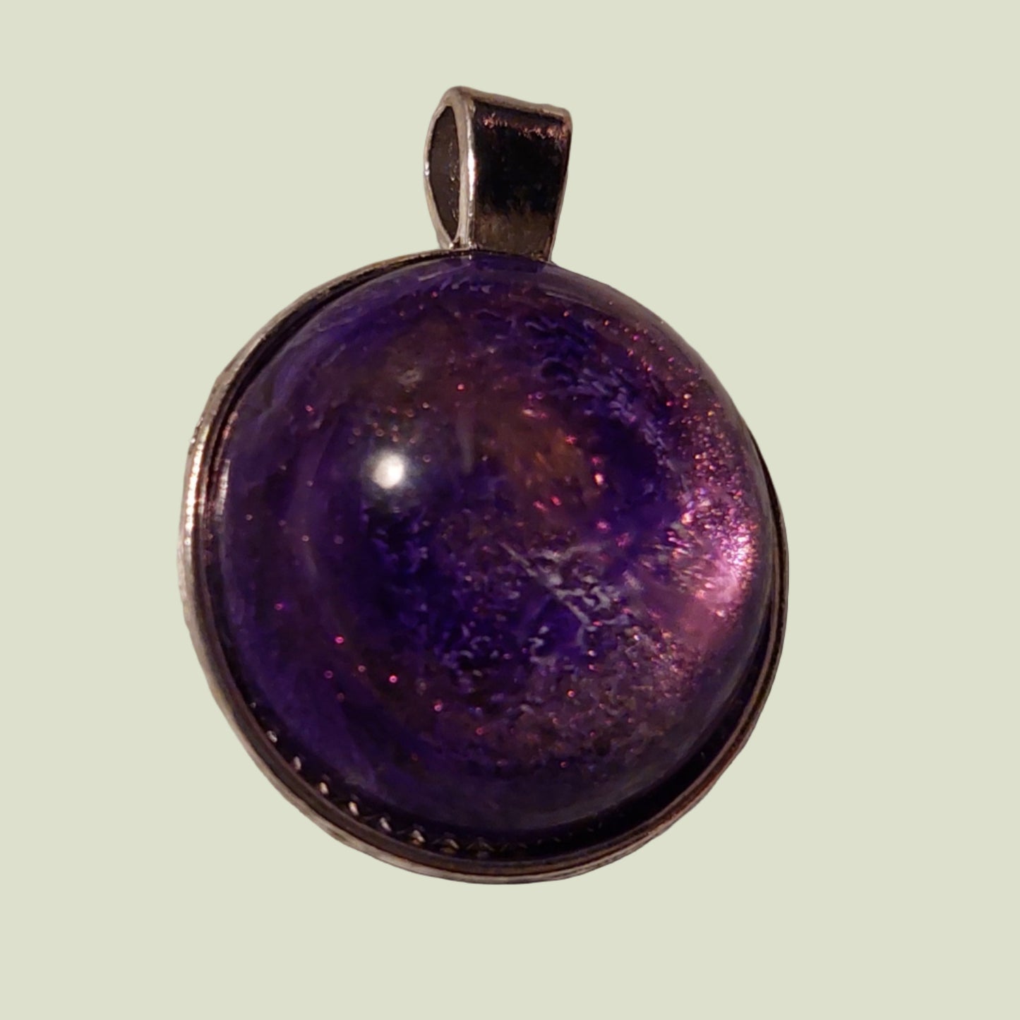 Purple pendant with a metallic rim on a light green background