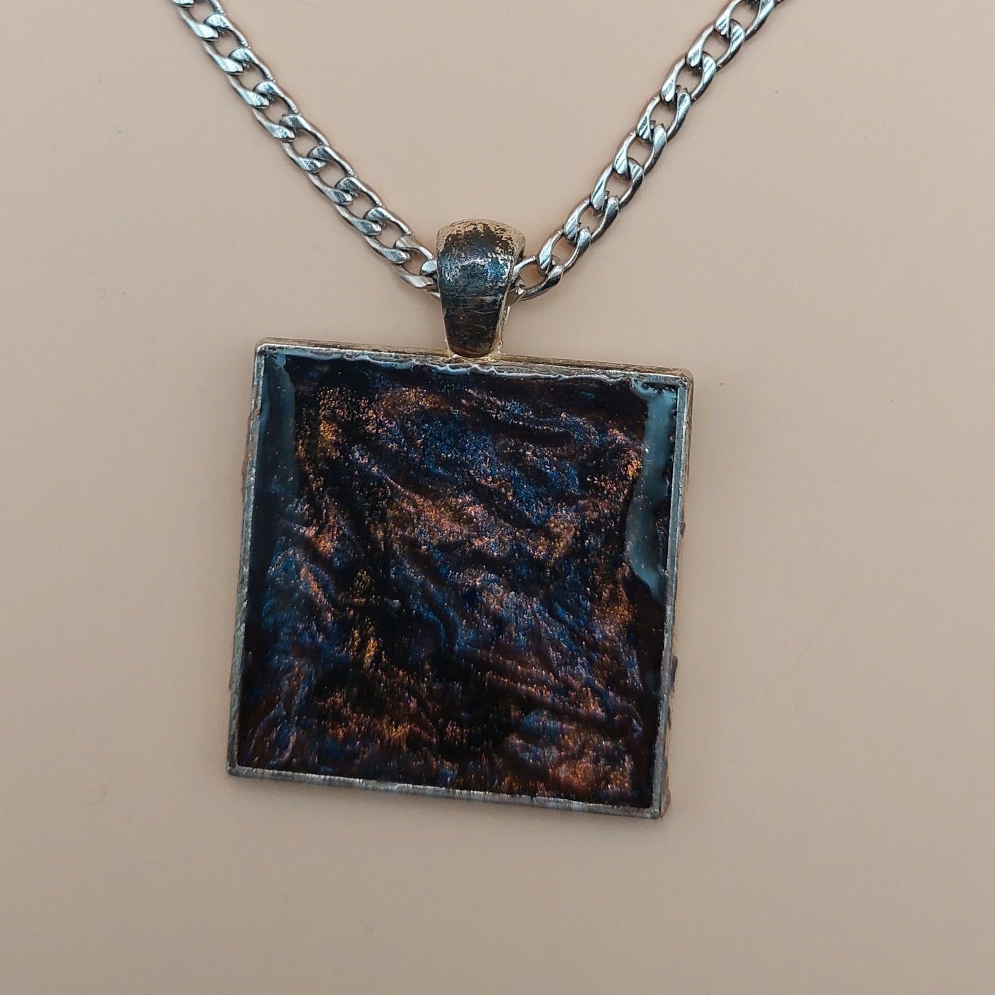 Necklace with a square pendant on a beige background