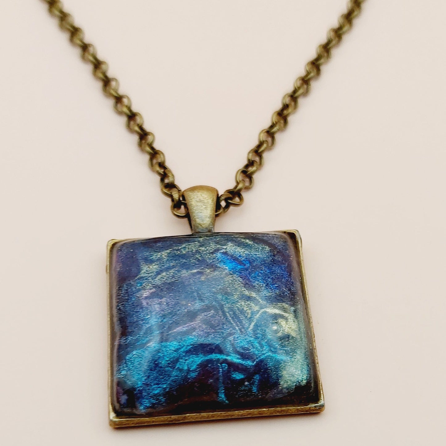 Necklace with a blue pendant on a beige background