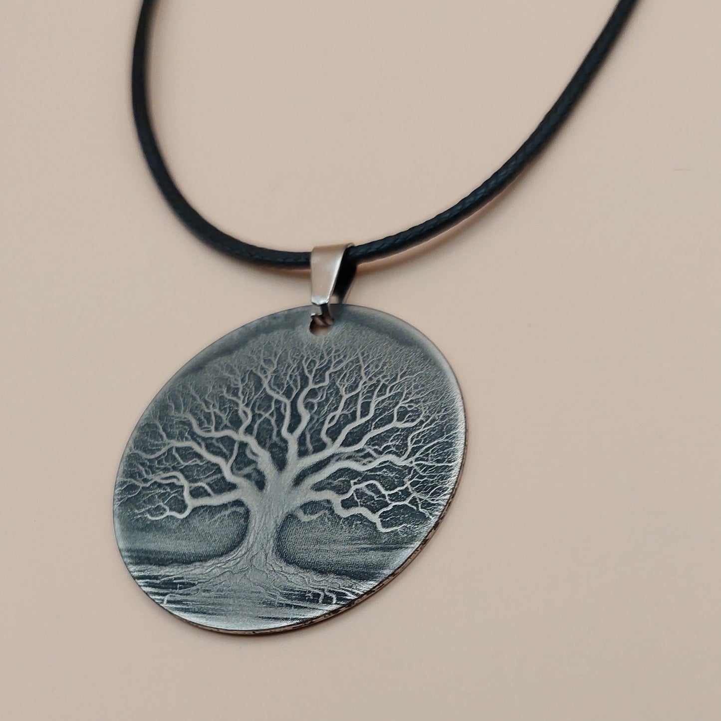 Necklace with a round pendant featuring an embossed design on a beige background