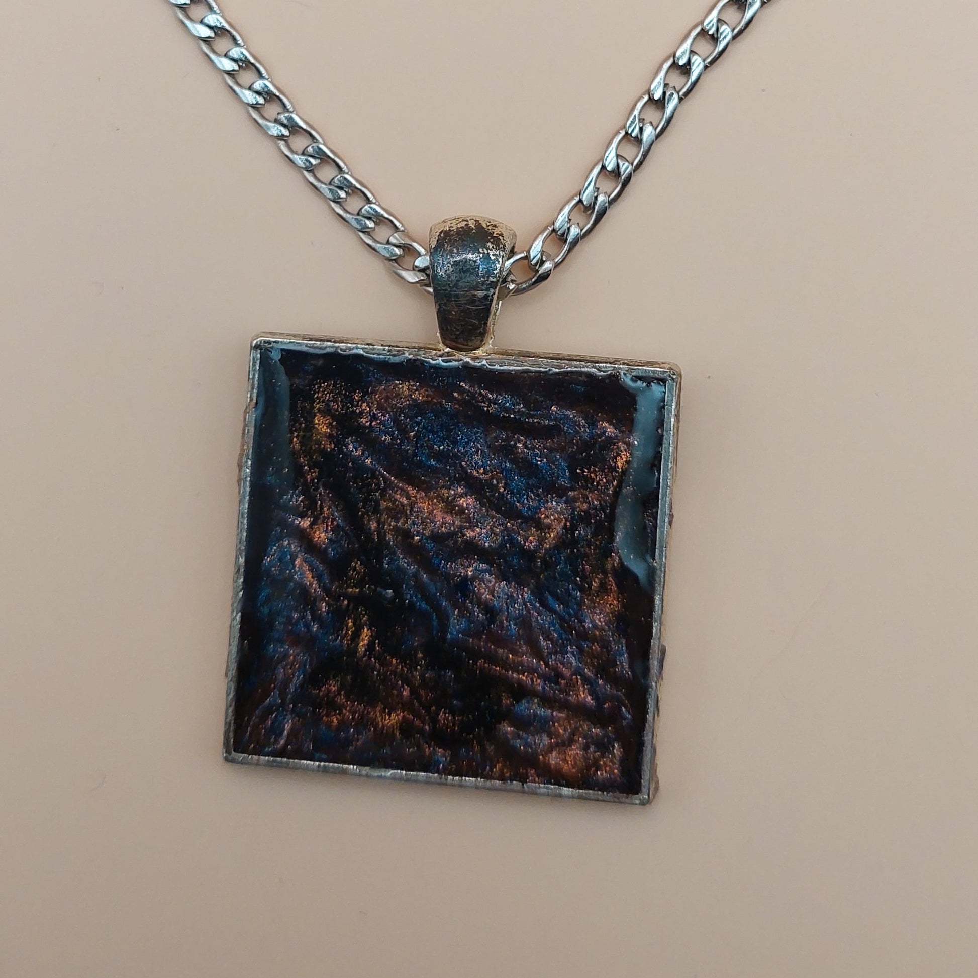 Necklace with a square pendant on a beige background