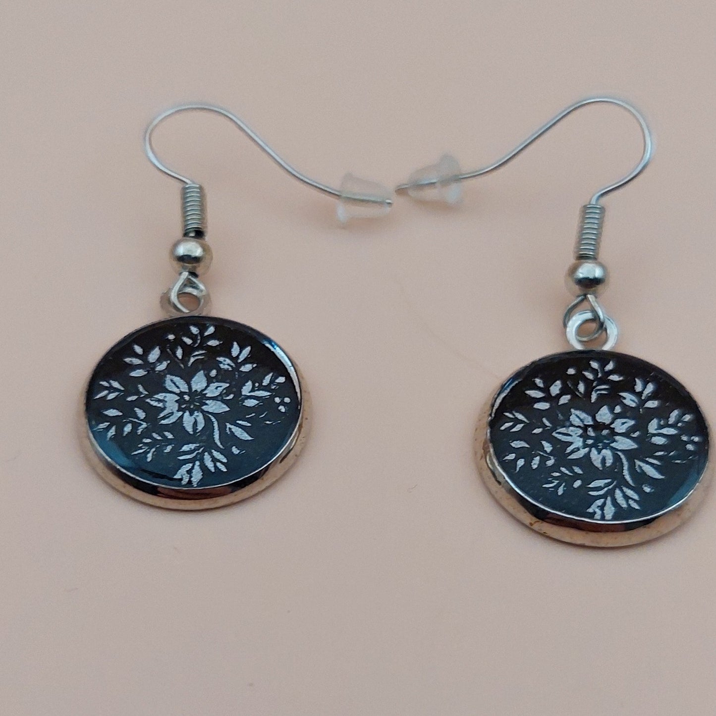 Cercei cu model floral argintiu pe fond negru