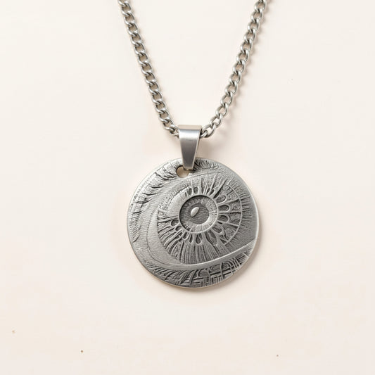 Silver necklace with a detailed pendant on a light beige background